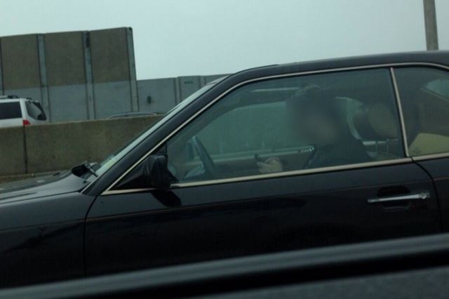 A distracted driver on the L.I.E. checks out his phone.